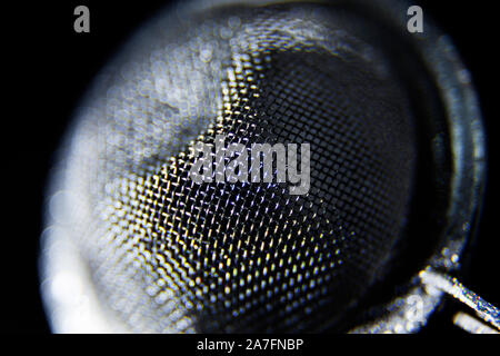 a tea strainer in close-up against black background Stock Photo