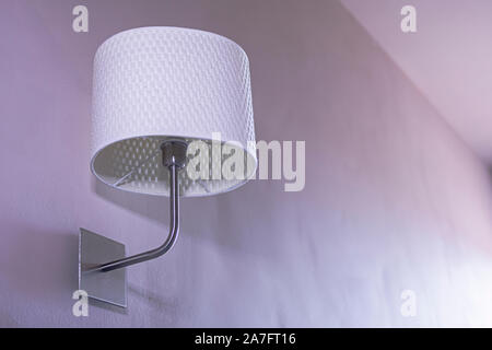 Wall light. Classic or Vintage style wall lamp. Textil and metal. Isolated, purple background. Stock Photo