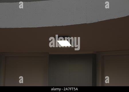 Single white ceiling light with led light, on the ceiling inside a corridor of the apartment. Stock Photo