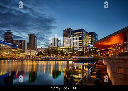 Night at MediacityUK Salford quays regenerated docks, Reid Architects designed Alchemist Media City with BBC studios and office HQ across the basin Stock Photo