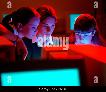 Children. Three schoolgirls using computer in classroom. Stock Photo