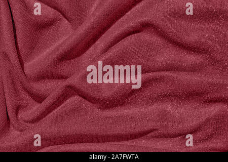 Dark red colored Background of draped fabric with silver lurex thread. Beautiful fashionable fabric with a shiny thread for making clothes. Textile te Stock Photo