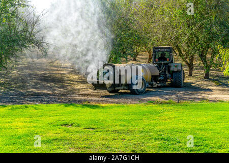 A power take off driven sprayer being used in and Almond orchard after harvest in the Central Valley of California USA Stock Photo