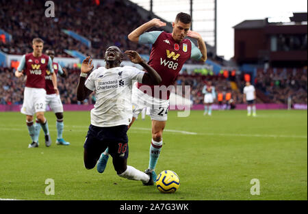 Liverpool's Sadio Mane goes down in the area under the challenge from Aston Villa's Frederic Guilbert and is booked for diving during the Premier League match at Villa Park, Birmingham. Stock Photo