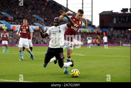 Liverpool's Sadio Mane goes down in the area under the challenge from Aston Villa's Frederic Guilbert and is booked for diving during the Premier League match at Villa Park, Birmingham. Stock Photo