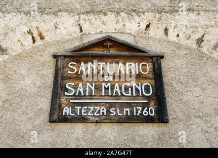 Close-up of the wooden sign on the façade of the sanctuary of Saint Magno (1475), Castelmagno, Grana Valley, Cuneo, Piedmont, Italy