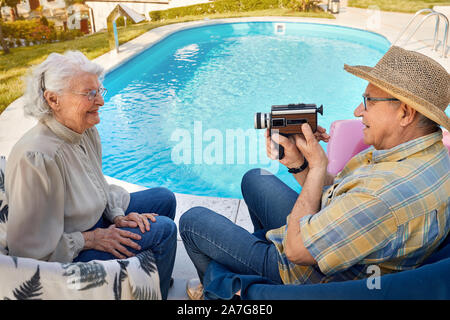 Happy senior man and woman spending time together and captures with a camera at holiday Stock Photo
