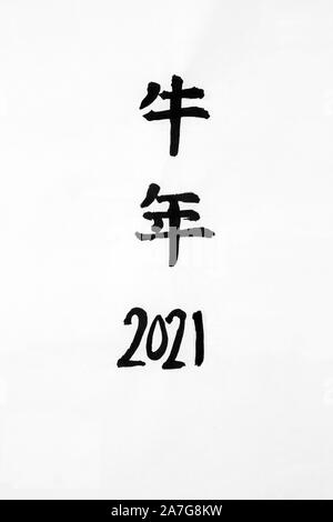 Chinese year of the ox 2021 calligraphy script on rice paper. Translation reads as Chinese Year of the Ox. Stock Photo