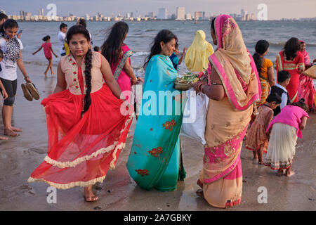 Festively dressed Indian women celebrating Chhath Puja, a Hindu festival in honor of sun god Suryadev, at Chowpatty Beach, Mumbai, India Stock Photo