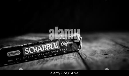 Perth, Scotland - 31 October 2019: Scrabble Board Game | Old Scrabble Box on Vintage Wooden Table | Black and White Stock Photo