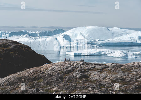 View towards Icefjord in Ilulissat. Icebergs from Kangia glacier in Greenland swimming with blue sky and clouds. Symbol of global warming. Photo taken Stock Photo