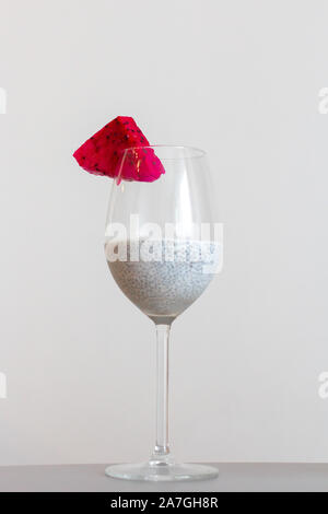 Glass of chia healthy food coconut pudding with banana, mango and dragon fruit on the white background. Healthy concept. Stock Photo