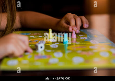 Multi-colored game chips with dice on the playing board. Board game. Stock Photo