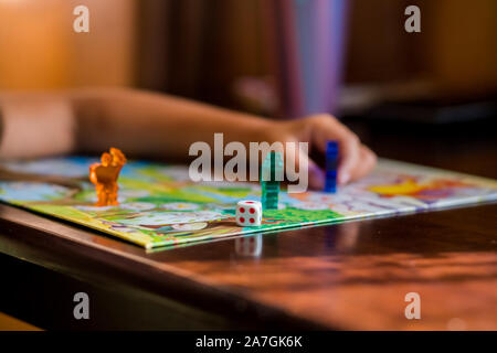 Multi-colored game chips with dice on the playing board. Board game. Stock Photo