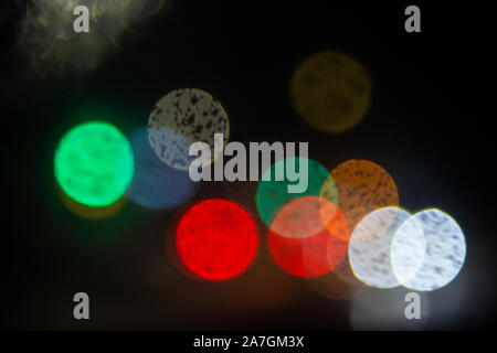 out of focus abstract car headlights in the rain with space for text on a dark background Stock Photo