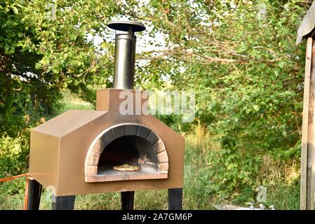 Cooking artisanal pizza outdoors in a wood fired Forno Bravo oven, made with organic ingredients at Inn Serendipity, Browntown, Wisconsin, USA Stock Photo