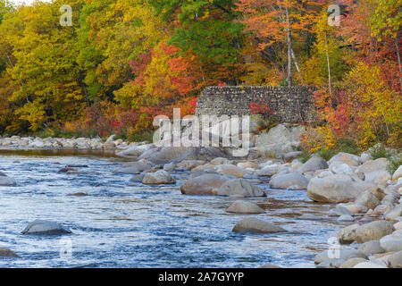 Looking downstream at remnants of the old 1900s Gravity Dam on the East Branch of the Pemigewasset River in Lincoln, New Hampshire during the autumn m Stock Photo