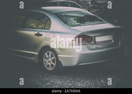 Broken rear glass of car, spread fragments of glass on asphalt Stock Photo