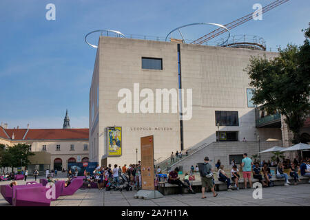 VIENNA, AUSTRIA - August 30, 2019: Viennese art pavilion and Mumok Museum. People listen to concerts, sitting on chairs, lying on purple benches. Stock Photo