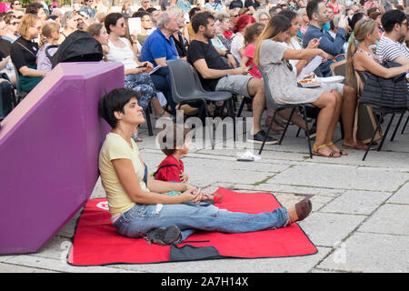 VIENNA, AUSTRIA - August 30, 2019: Viennese art pavilion and Mumok Museum. People listen to concerts, sitting on chairs, lying on purple benches. Stock Photo