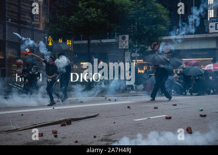 A protester throws a tear gas round back at the police during the demonstration.Pro-democracy protesters once again took to the streets in their latest battle against the government. Despite the full withdrawal of the extradition bill, the initial catalyst of unrest, protesters continue to reemphasize that the remaining 4 demands must be met. Protesters clashed violently with police, resulting in numerous injuries and arrests. Stock Photo