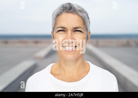 Portrait of a smiling middle-aged woman by the ocean Stock Photo