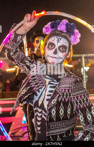 White painted ghostly faces at Southport.  ' Bring on the fire project' display at the Day Of The Dead' Festival – November is the host month to Mexico's Day of the Dead – and Southport Pleasureland staged its own twist on the spooky Mexican celebration with explosive cascade of colours and patterns created while dancing and moving with light and vibrant revelry in a feast for the senses. Stock Photo