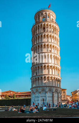 pisa, Italy - August 28, 2018: Tourists enjoiying sunset hour by Pisa Leaning Tower Stock Photo