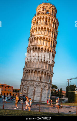 pisa, Italy - August 28, 2018: Tourists enjoiying sunset hour by Pisa Leaning Tower Stock Photo