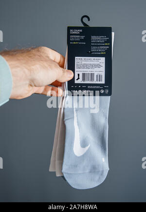 Paris, France - Oct 26, 2019: Man hand holding a pair of new Nike Elite Over-The-Calf compression socks with Dri-Fit technology - rear view of the pac Stock Photo