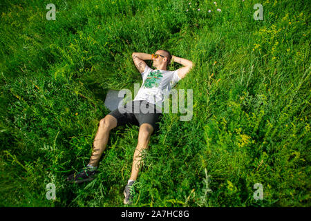 Freelancer at work lying on the grass in the meadow with laptop Stock Photo