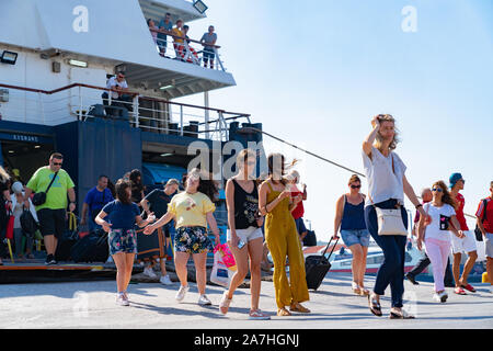 Skiathos Greece - August 4 2019; People on and leaving Greek Island ferry at wharf at Skiathos. Stock Photo