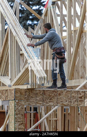 Housing construction workers installing roof trusses on a new home Stock Photo