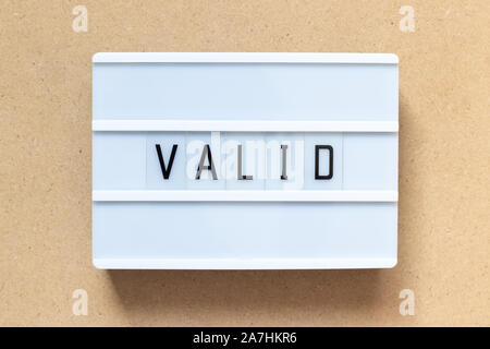 White lightbox with word valid on wood background Stock Photo