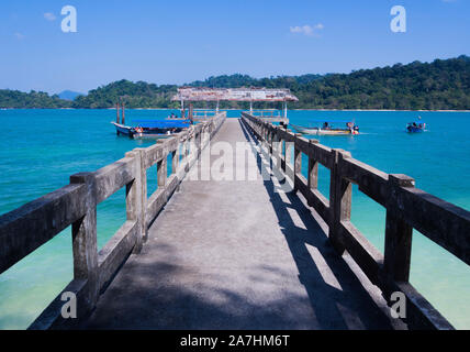 Vintage jetty in the backdrop of clear blue waters and mountain. Stock Photo