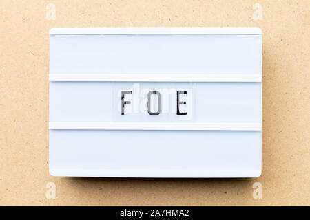 White lightbox with word foe on wood background Stock Photo