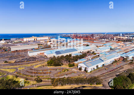 Mills, warehouses and storage yards of Port Kembla industrial site and sea port near Wollongong in Australia. Elevated aerial view across site towards Stock Photo