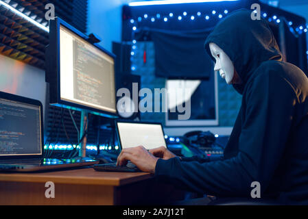 Hacker in mask and hood, account hacking Stock Photo