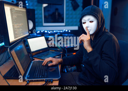 Hacker in mask and hood, network hacking Stock Photo