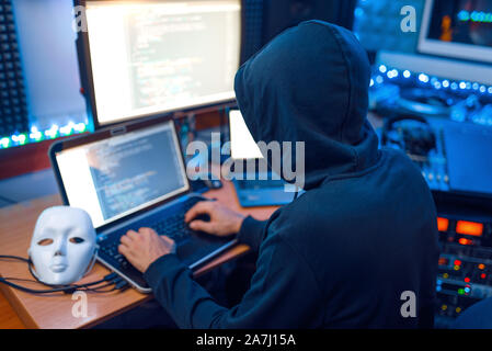 Hacker in mask and hood, account hacking Stock Photo