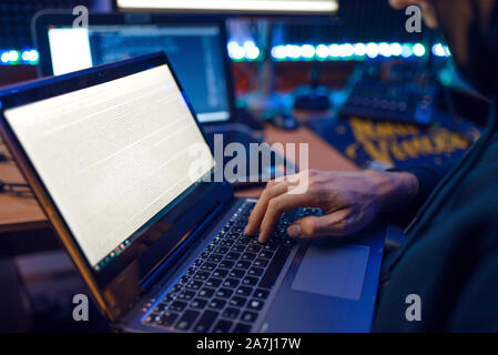 Hacker in hood shows thumbs up, network criminal Stock Photo