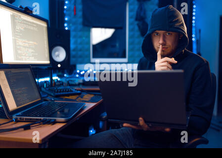 Hacker in hood shows thumbs up, network criminal Stock Photo