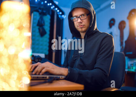 Hacker in hood at his workplace, corporate hacking Stock Photo