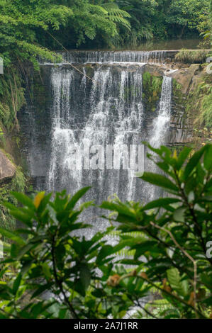 Small waterfall hitting and splash on the surface of hard rocks, near Taipei, Taiwan - On a sunny day during summer time Stock Photo