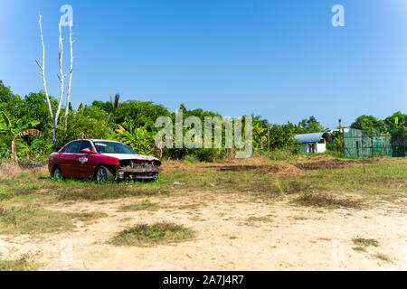 An old car left abandoned on an empty field Stock Photo