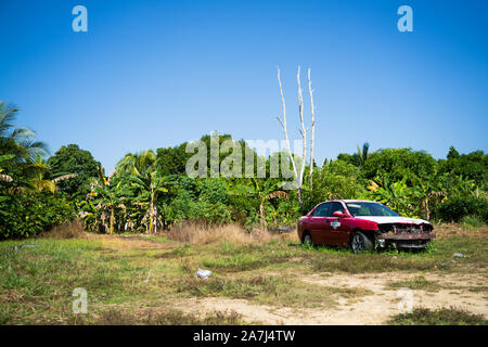 An old car left abandoned on an empty field Stock Photo