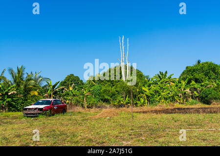 An old car left abandoned on an empty field Stock Photo
