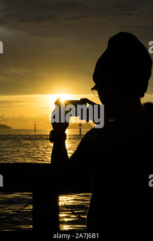 a couple of people in the shadows photographing the sunset Stock Photo