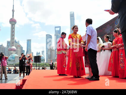 Parents give gifts to the newly-weds by the Huangpu river in Shanghai, China, 19 September 2019.   15 couples held group weddings by the Huangpu river Stock Photo