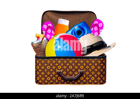 Packed vintage suitcase full of items for summer holidays travel, vacation, travel and trip isolated on white Stock Photo